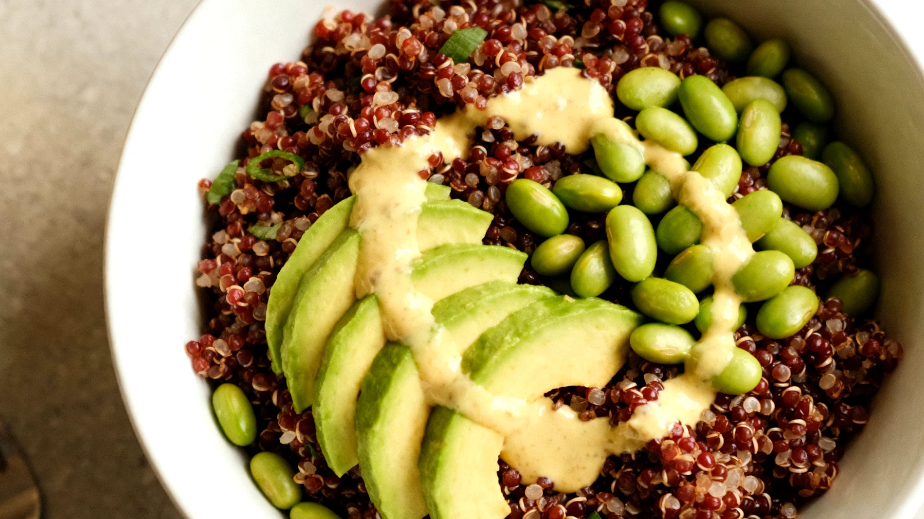 Insalata di quinoa rossa con avocado, edamame e tahin al limone"
