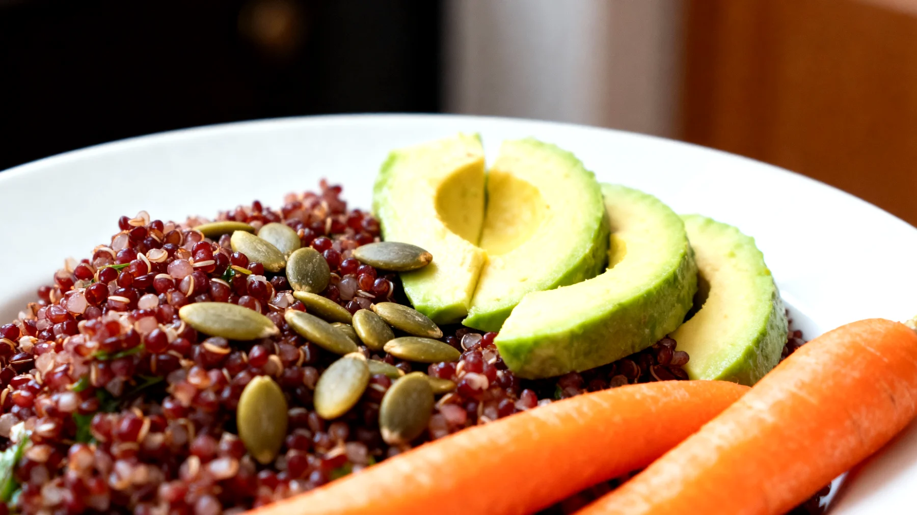 Insalata di quinoa rossa con avocado, semi di zucca e carote crude"